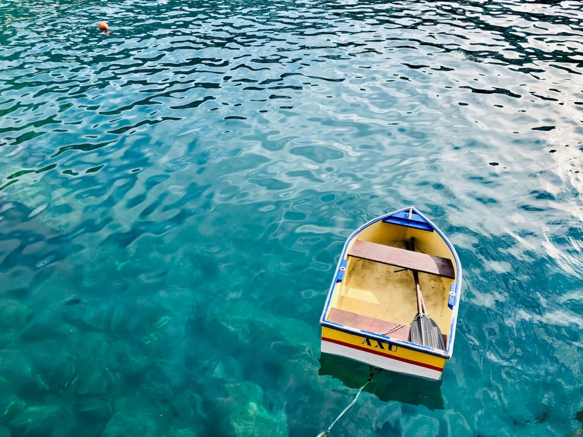 A small wooden boat on clear water.